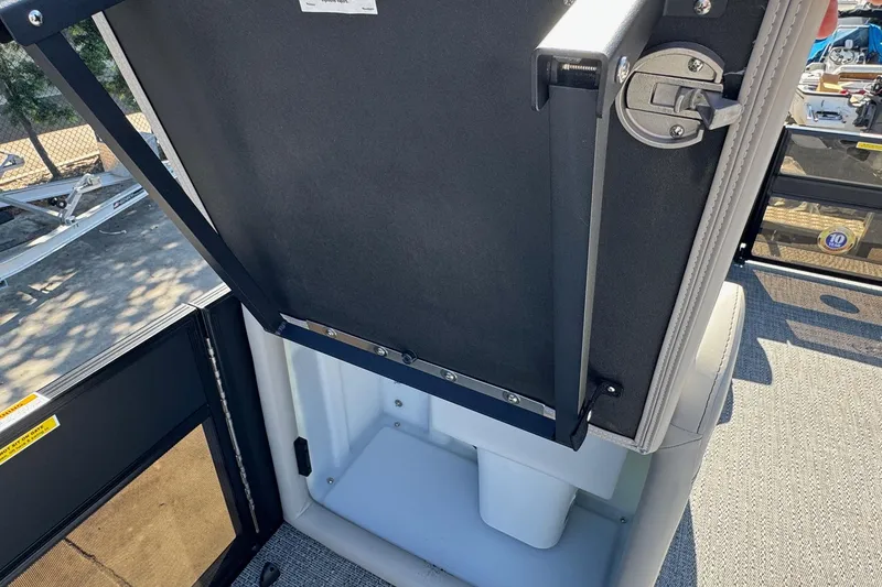 Slide: The Image of 2026 Barletta Cabrio 22UC boat storage compartment with open lid and latch mechanism. - 50
