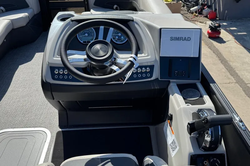 Slide: The Image of 2026 Barletta Cabrio 22UC boat dashboard with steering wheel and Simrad display. - 54