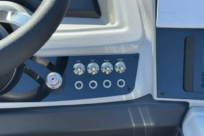 Slide: The Image of Control panel of 2026 Barletta Cabrio 22UC boat with switches and steering wheel. - 57
