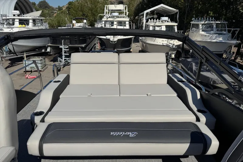 Slide: The Image of 2026 Barletta Cabrio 22UC pontoon boat with luxurious seating, docked among other boats. - 66