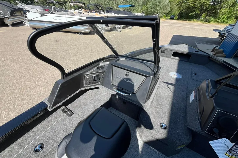 Slide: The Image of 2026 Crestliner 1850 Fish Hawk interior with seating and dashboard, parked outdoors. - 10