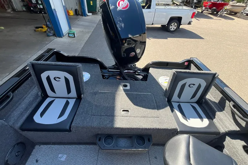 Slide: The Image of 2026 Crestliner 1850 Fish Hawk boat interior with seating and motor, parked outdoors. - 17