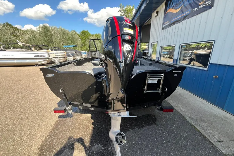 Slide: The Image of 2026 Crestliner 1850 Fish Hawk boat with powerful outboard motor, parked outdoors. - 2