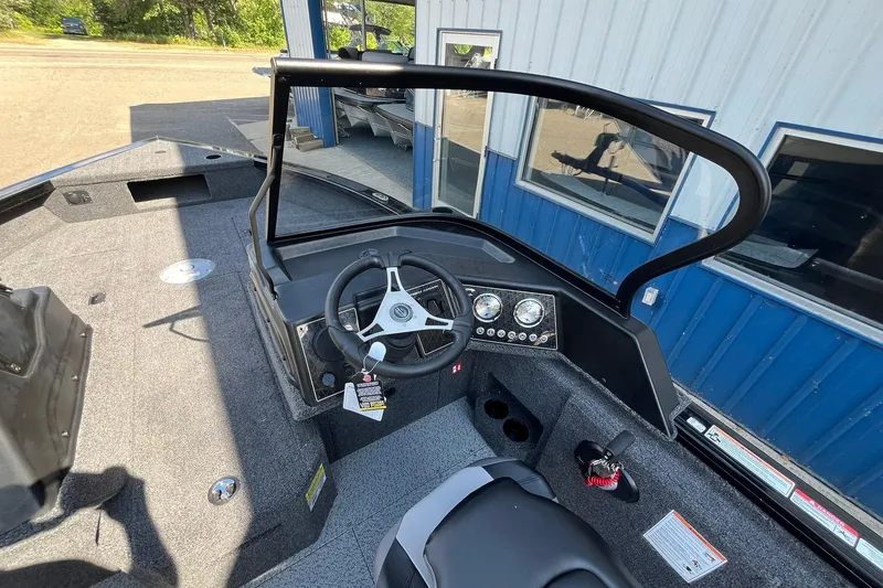 Slide: The Image of 2026 Crestliner 1850 Fish Hawk boat interior with steering wheel and dashboard controls. - 9