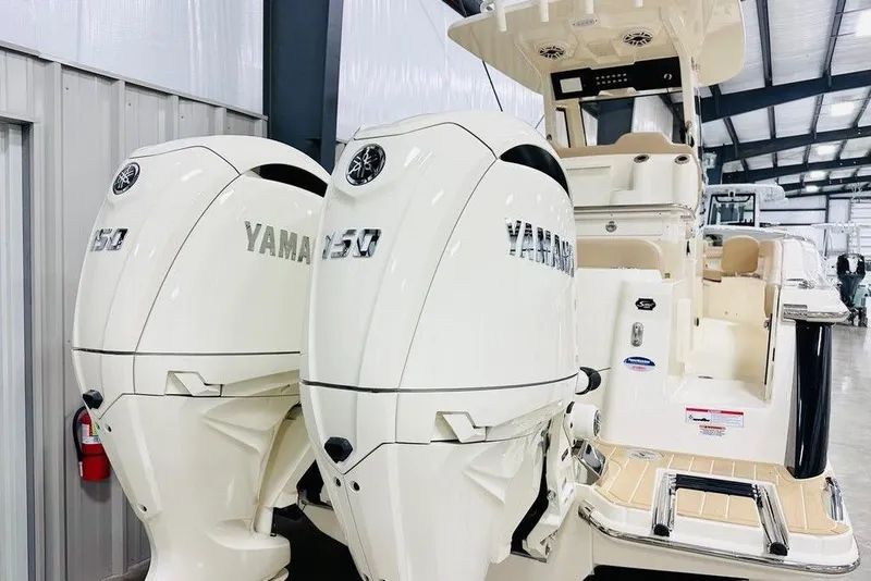 Slide: The Image of 2026 Scout 260 LXF boat with dual Yamaha 150 engines in a showroom. - 20