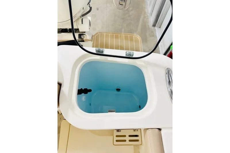 Slide: The Image of Livewell compartment on 2026 Scout 260 LXF boat, featuring a clear lid and blue interior. - 25