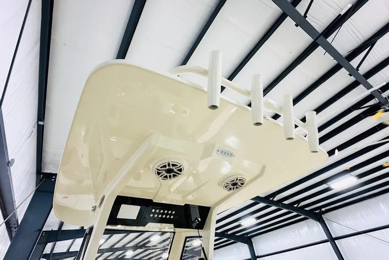 Slide: The Image of 2026 Scout 260 LXF boat interior with rod holders and speakers in a warehouse. - 7