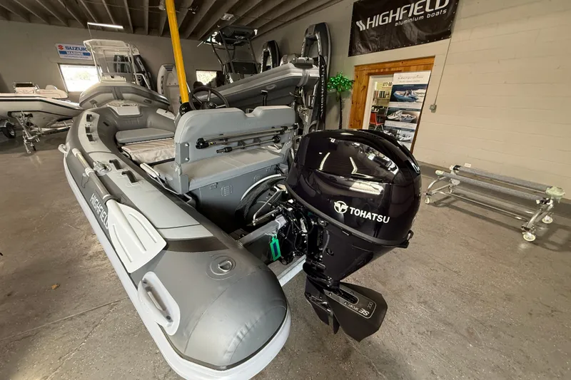 Slide: The Image of 2026 Highfield Classic 360 FCT boat with Tohatsu outboard motor in showroom. - 11