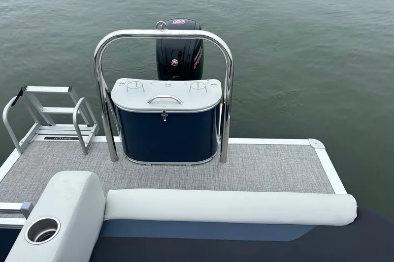 Slide: The Image of 2025 Avalon Venture Cruise Rear Bench with motor, ladder, and seating on calm water. - 10