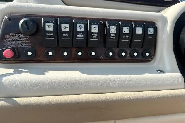 Slide: The Image of Control panel of a 2001 Crest Grand Caribbean boat with various switches and buttons. - 12