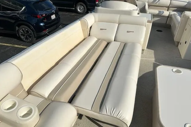 Slide: The Image of 2001 Crest Grand Caribbean boat interior with beige seating and cup holders. - 15