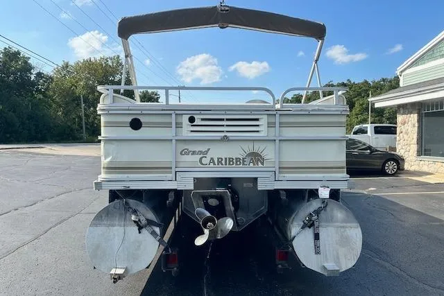 Slide: The Image of 2001 Crest Grand Caribbean pontoon boat, rear view, parked outdoors under a clear blue sky. - 2