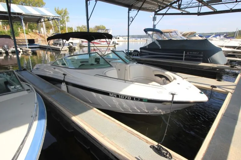 Slide: The Image of 2002 Chaparral 220 SSi boat docked in a marina under a canopy. - 1