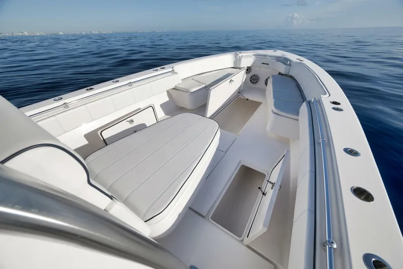Slide: The Image of 2023 Contender 39 ST boat interior with seating and storage, on calm ocean waters. - 24