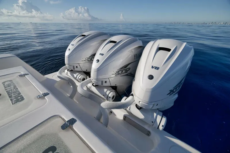 Slide: The Image of 2023 Contender 39 ST boat with triple Yamaha V8 outboard engines on calm ocean. - 27