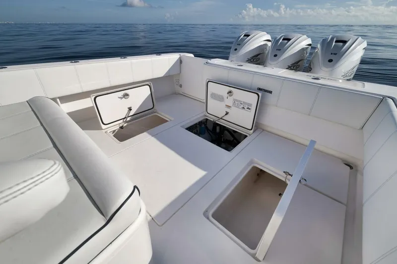 Slide: The Image of 2023 Contender 39 ST boat interior with open storage compartments and triple outboard engines. - 30