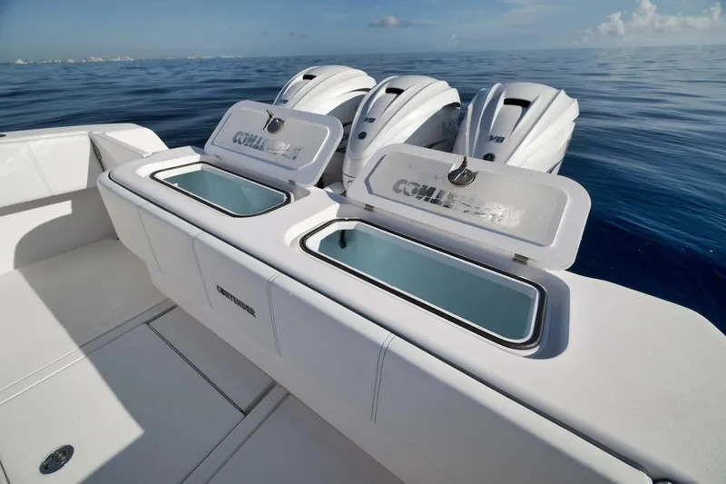 Slide: The Image of 2023 Contender 39 ST boat with open storage compartments and triple outboard engines. - 31