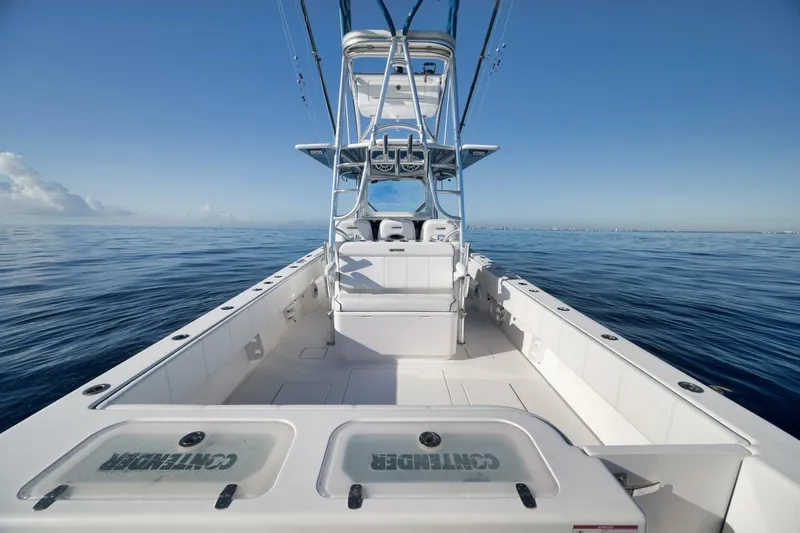 Slide: The Image of 2023 Contender 39 ST boat on calm ocean waters under clear blue sky. - 32