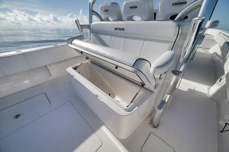Slide: The Image of 2023 Contender 39 ST boat interior with open storage compartment, sleek design, and ocean backdrop. - 33