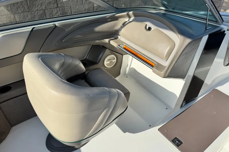 Slide: The Image of Interior of a 1996 Cobalt 232 boat featuring beige seating and dashboard. - 19