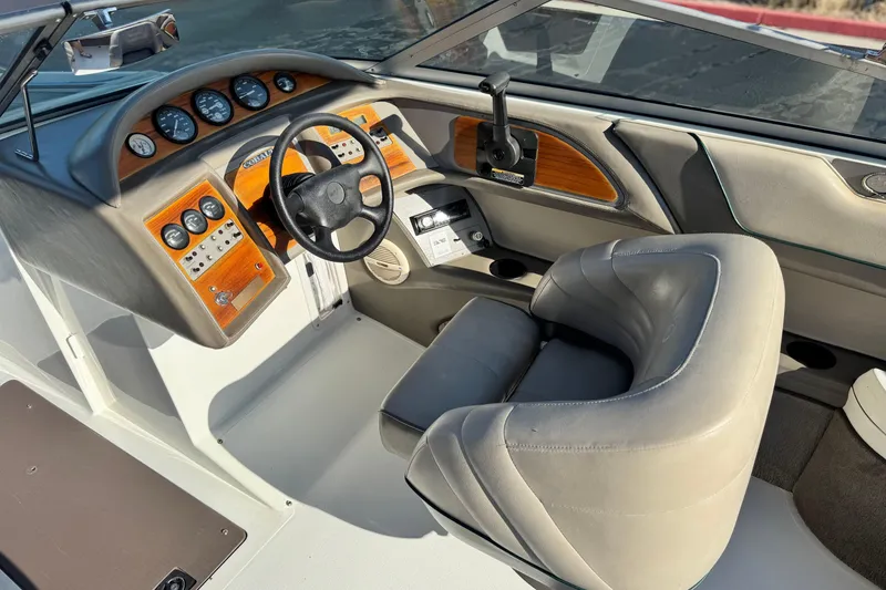 Slide: The Image of 1996 Cobalt 232 boat interior with steering wheel, gauges, and leather seating. - 21