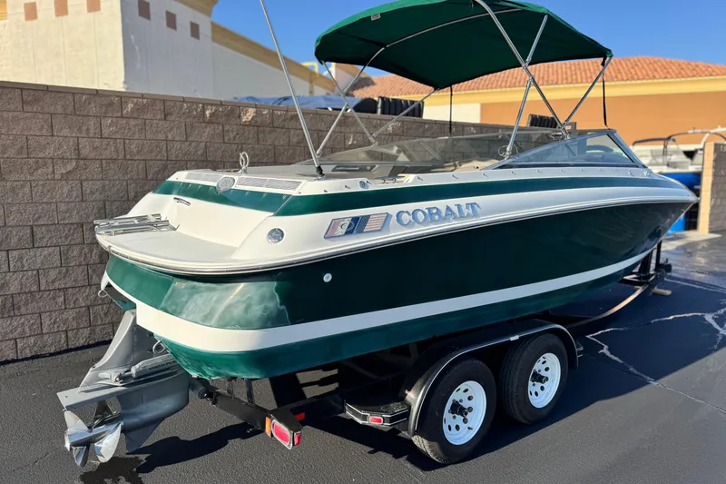 Slide: The Image of 1996 Cobalt 232 boat with green hull and canopy on a trailer. - 5