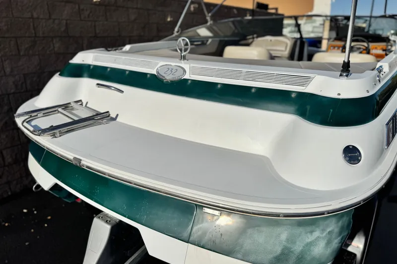Slide: The Image of 1996 Cobalt 232 boat, rear view, white and green exterior, docked. - 7