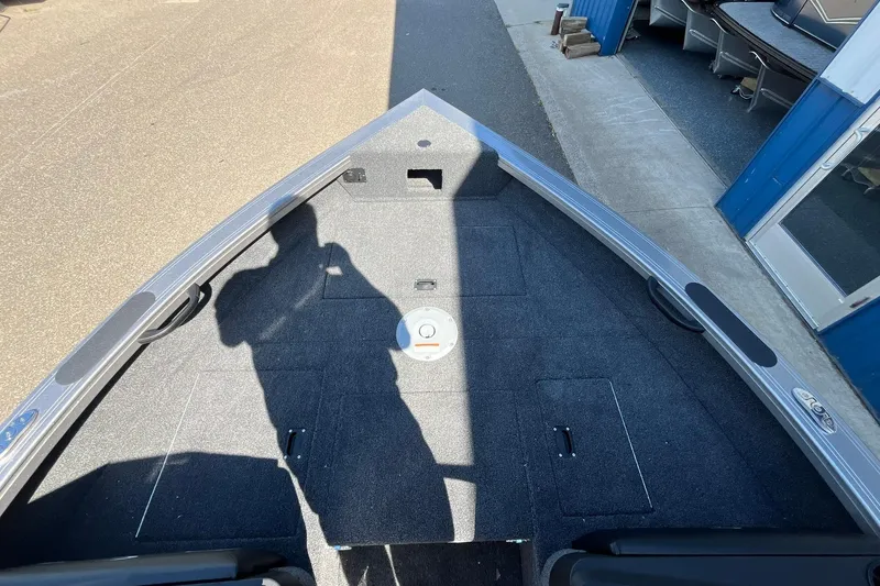 Slide: The Image of 2026 Crestliner 1750 Super Hawk boat interior with carpeted deck and storage compartments. - 10