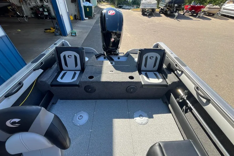 Slide: The Image of 2026 Crestliner 1750 Super Hawk interior with seating and motor, parked outdoors. - 14