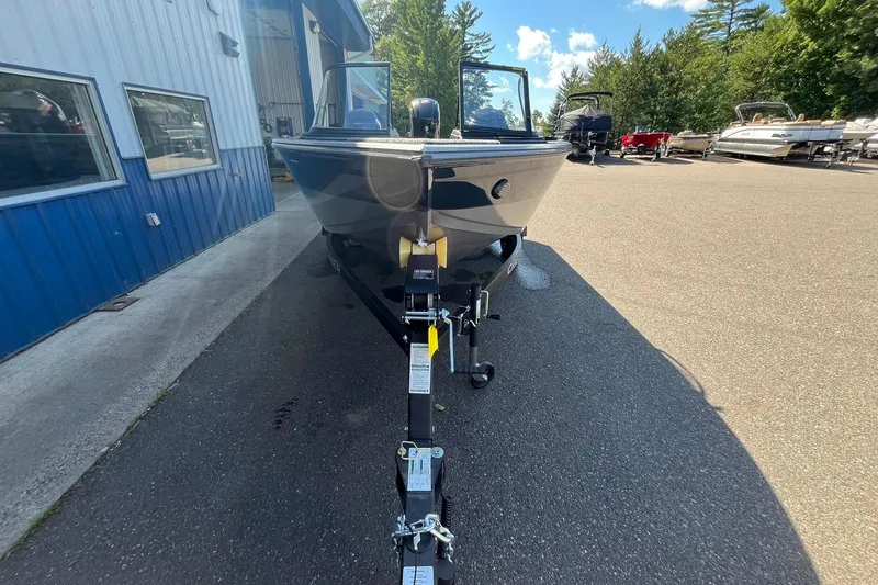 Slide: The Image of 2026 Crestliner 1750 Super Hawk boat on trailer, parked outdoors near blue building. - 5