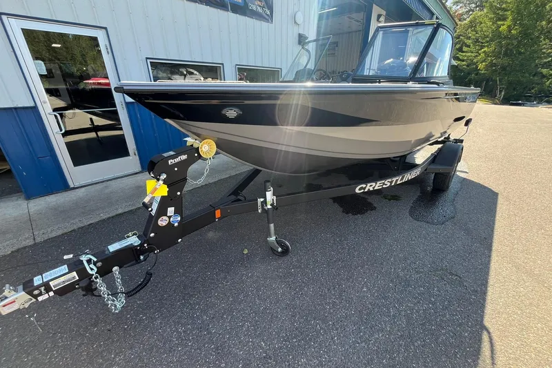 Slide: The Image of 2026 Crestliner 1750 Super Hawk boat on trailer, parked outside a building. - 6