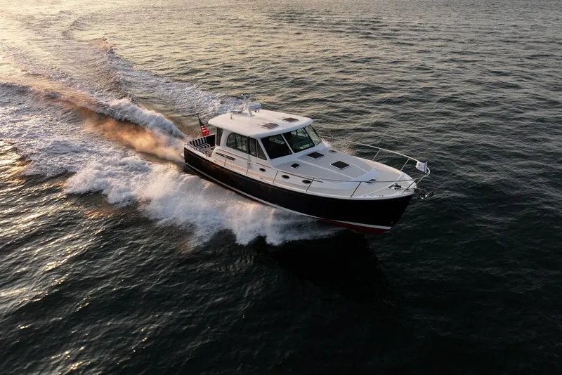 Slide: The Image of 2026 Back Cove 412 cruising on open water at sunset. - 10