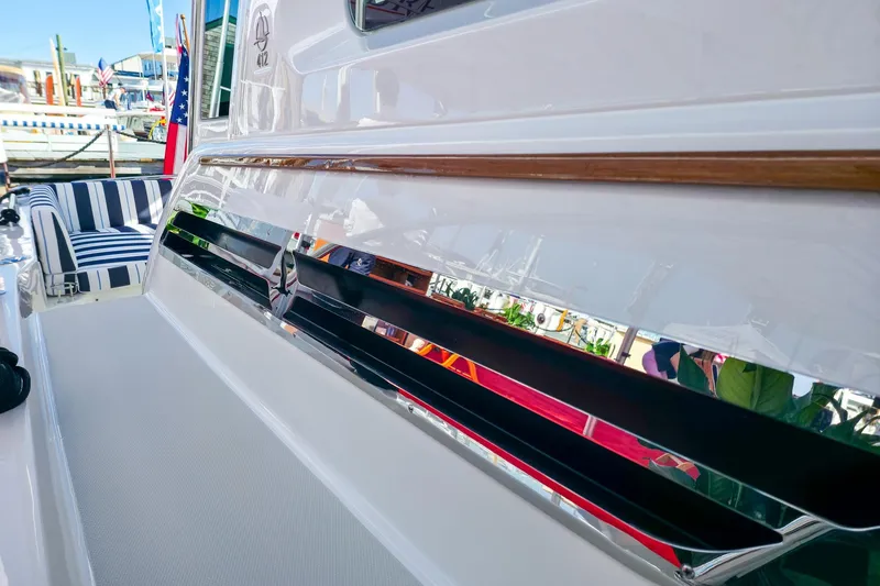 Slide: The Image of 2026 Back Cove 412 yacht with sleek design and striped seating at a marina. - 17
