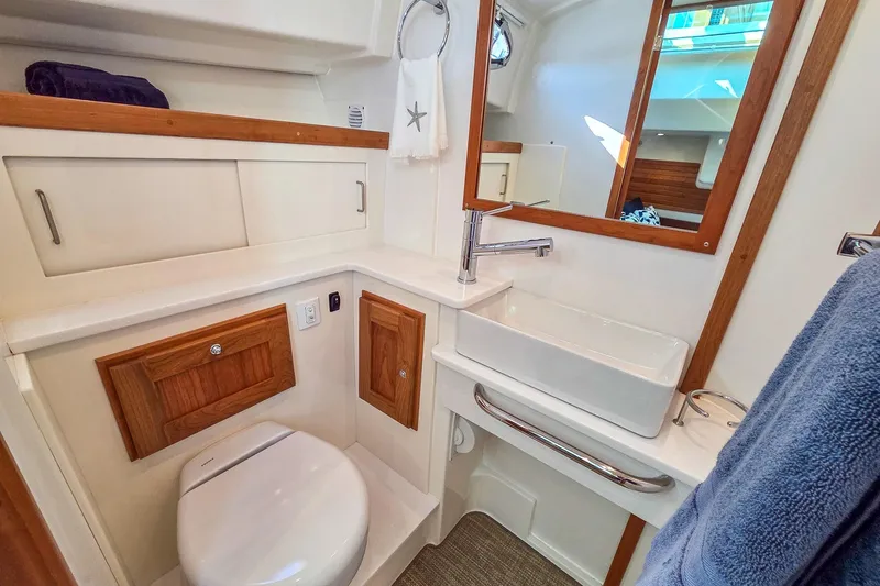 Slide: The Image of Bathroom interior of 2026 Back Cove 412 yacht, featuring modern sink and wooden accents. - 35