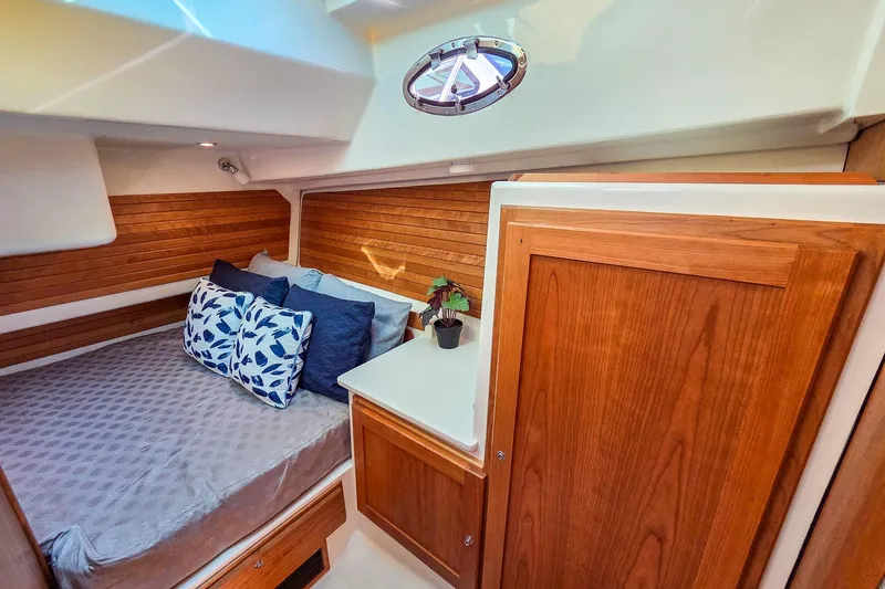Slide: The Image of 2026 Back Cove 412 cabin interior with cozy bed, wooden accents, and decorative pillows. - 36