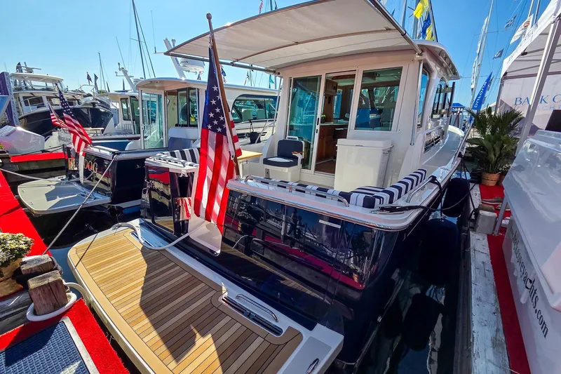Slide: The Image of 2026 Back Cove 412 yacht docked, featuring American flag and elegant deck design. - 43