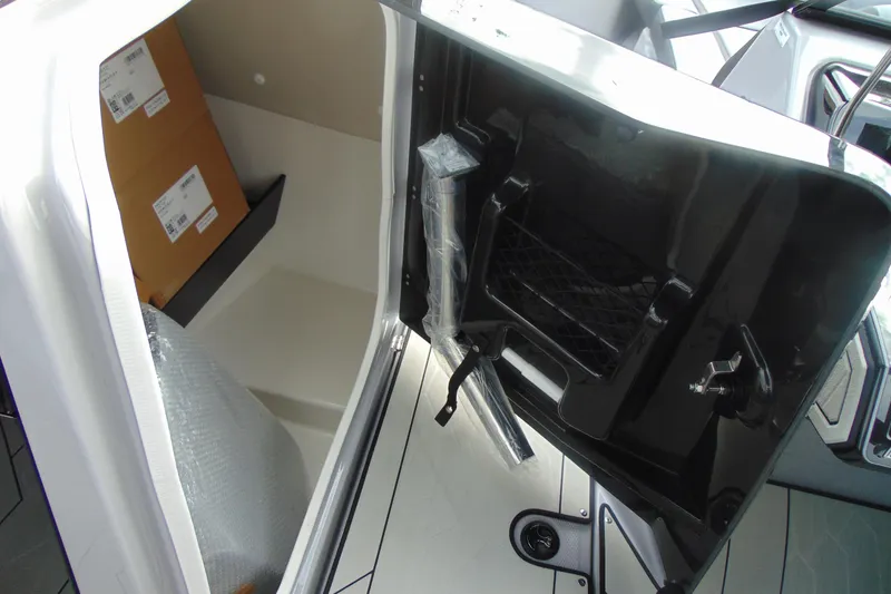Slide: The Image of 2026 Yamaha Boats 255XD storage compartment with packaging materials and sleek interior design. - 26