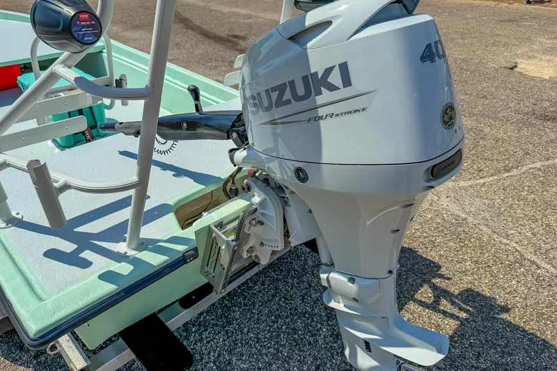 Slide: The Image of Custom 15' Tiller Skiff 2021 with Suzuki 40HP outboard motor, parked on pavement. - 10