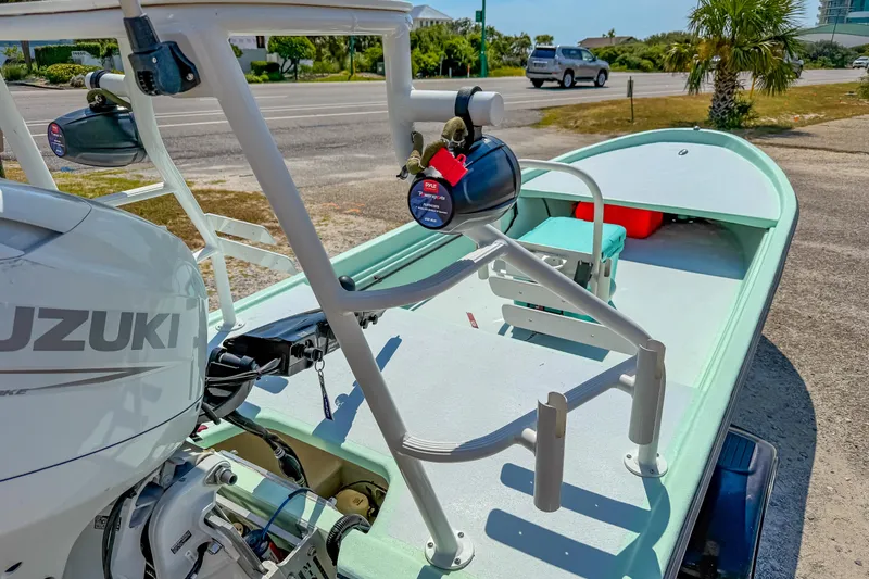 Slide: The Image of 2021 Custom 15' Tiller Skiff with Suzuki outboard motor, parked near a road. - 12