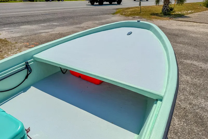 Slide: The Image of Custom 2021 15' Tiller Skiff boat on roadside, showcasing deck and storage area. - 14