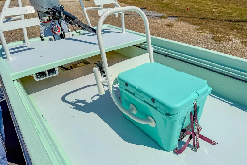 Slide: The Image of 15' Tiller Skiff boat with teal cooler on deck, 2021 model. - 15