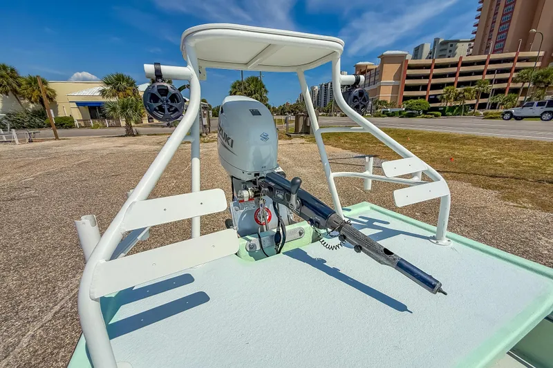 Slide: The Image of Custom 2021 15' Tiller Skiff with Suzuki outboard motor, parked near buildings. - 16