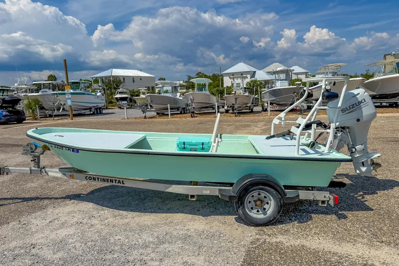 Slide: The Image of 2021 Custom 15' Tiller Skiff with Suzuki motor on trailer, parked in a boatyard. - 4