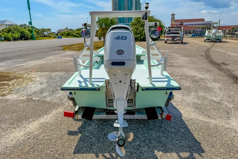 Slide: The Image of Custom 15' Tiller Skiff 2021 with outboard motor on trailer, parked outdoors. - 8