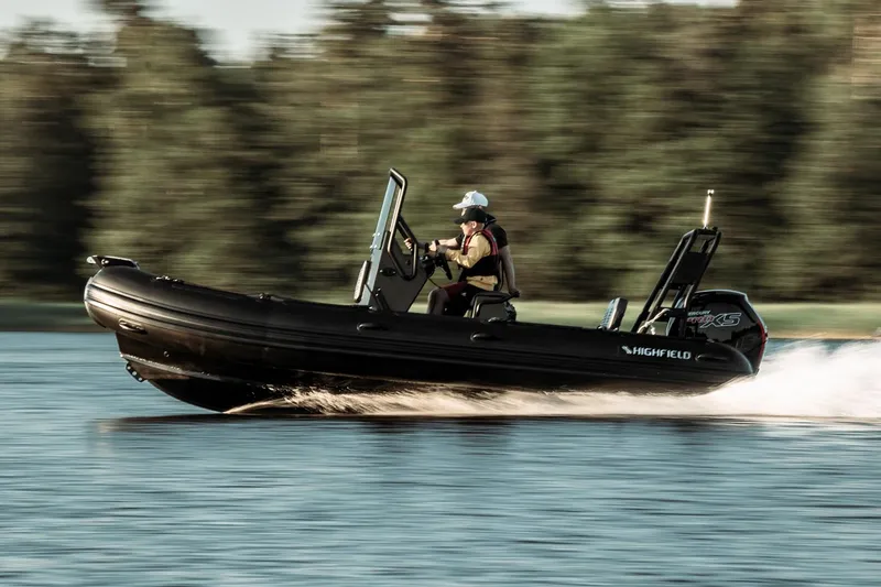 Slide: The Image of 2026 Highfield Patrol 540 boat with Yamaha engine displayed indoors. - 2