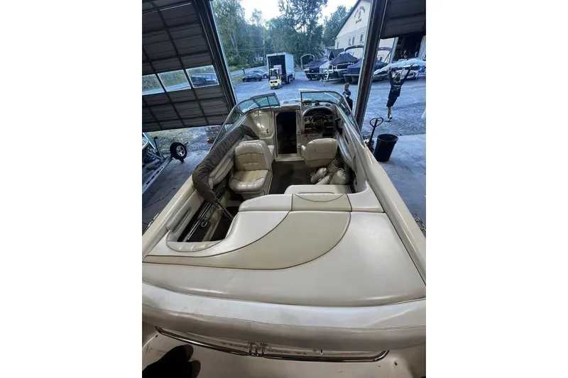 Slide: The Image of 1994 Sea Ray 220 boat interior with white leather seating in a garage setting. - 10