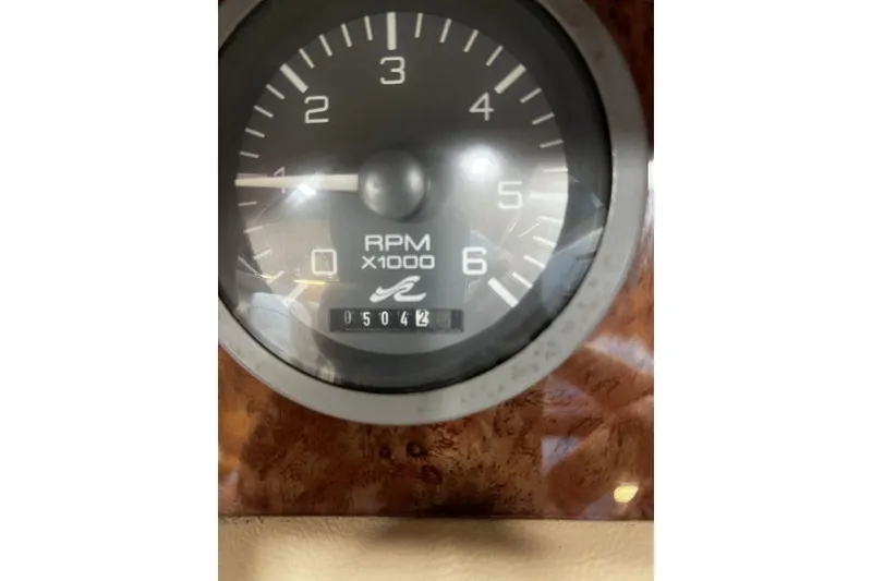 Slide: The Image of Close-up of a 1994 Sea Ray 220 RPM gauge, showing 5042 hours. - 11
