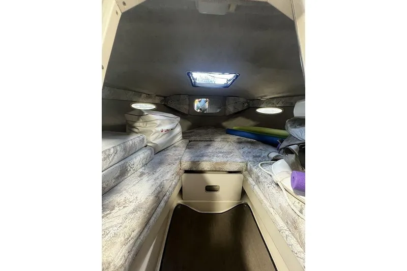 Slide: The Image of Interior cabin of 1994 Sea Ray 220 boat with cushioned seating and storage. - 12