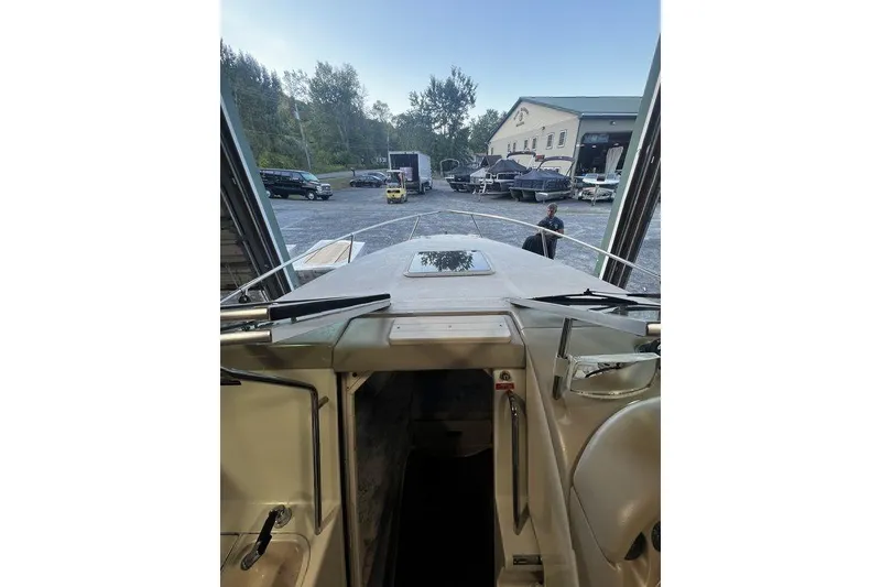 Slide: The Image of 1994 Sea Ray 220 boat interior view with open cabin door, parked outdoors. - 14
