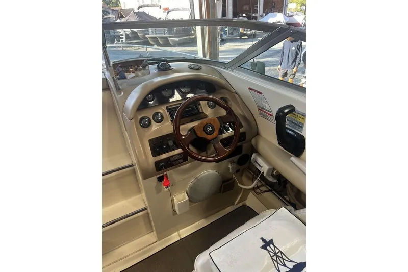 Slide: The Image of 1994 Sea Ray 220 boat dashboard with steering wheel and control panel. - 2